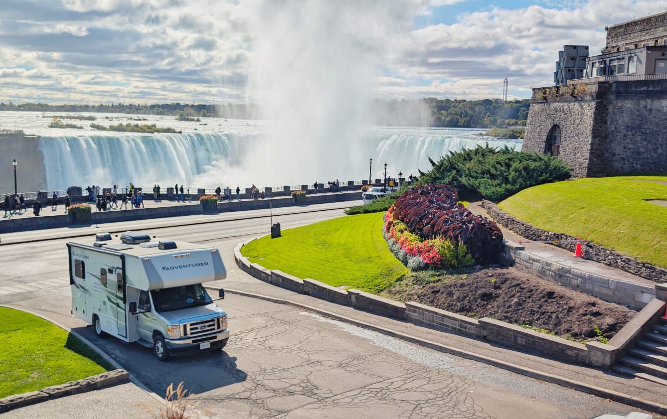 A rv is parked in front of a waterfall.