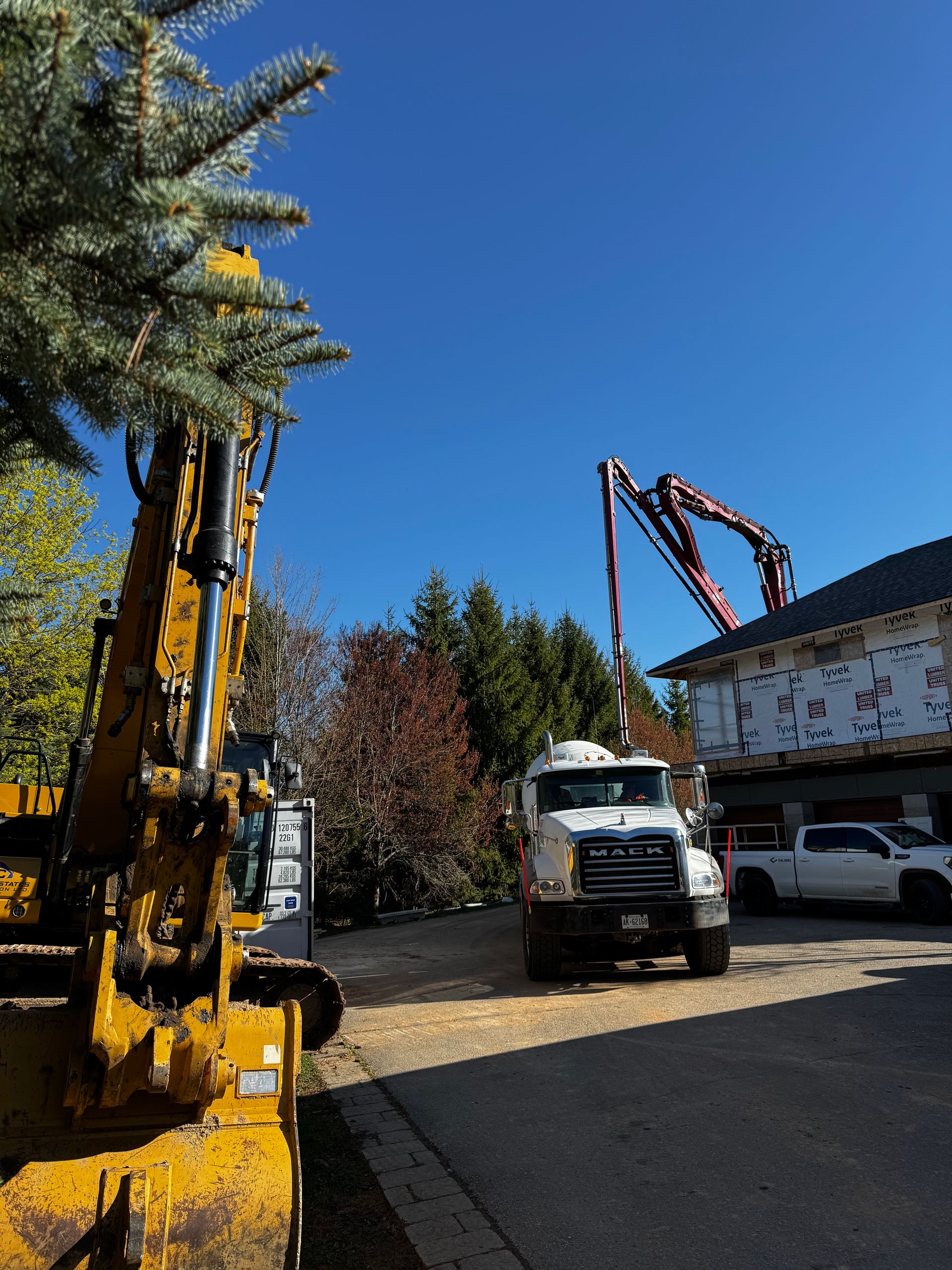 A truck with a crane attached to it is parked in front of a house.