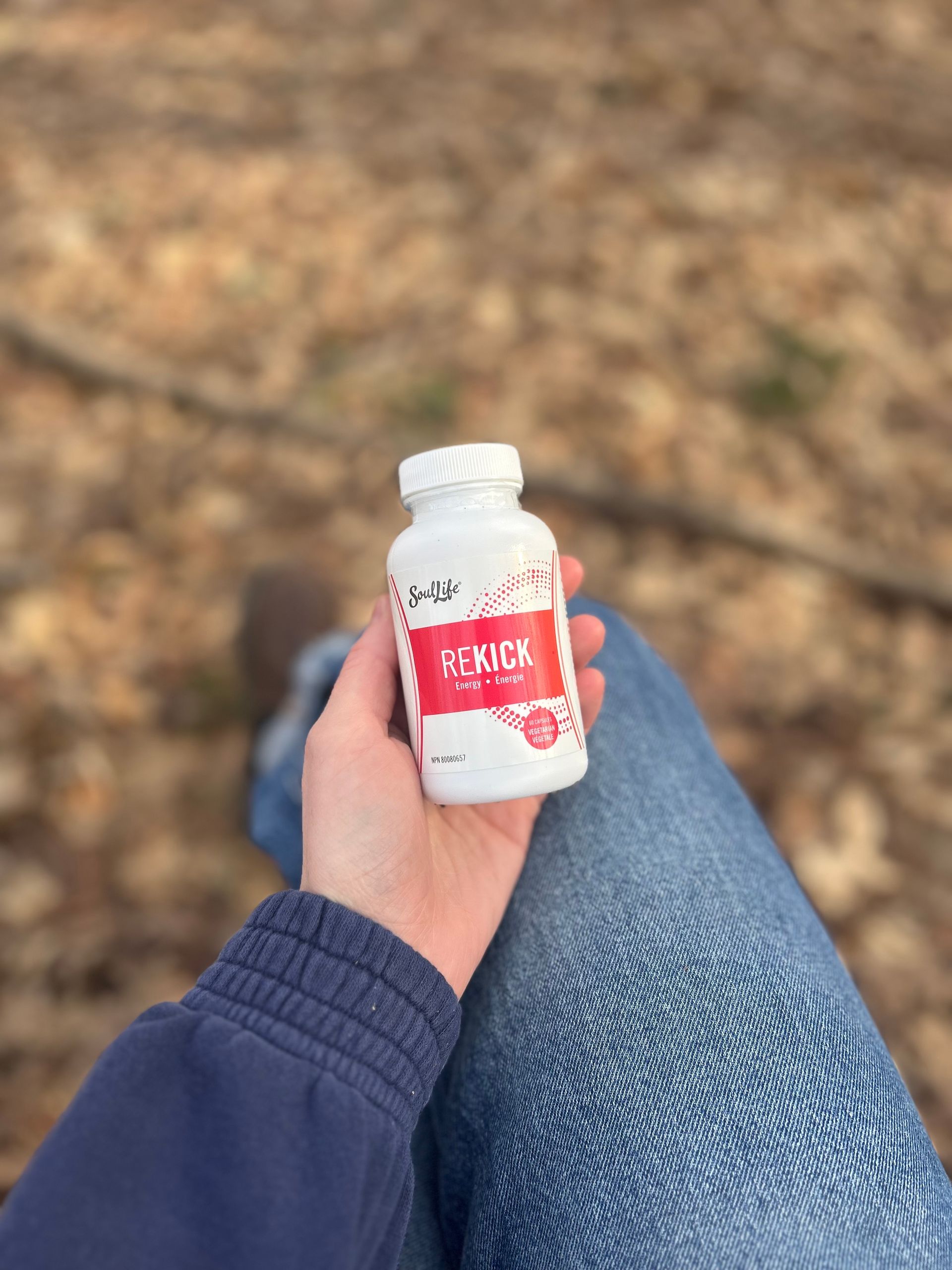 A person is holding a bottle of pills in their hand.