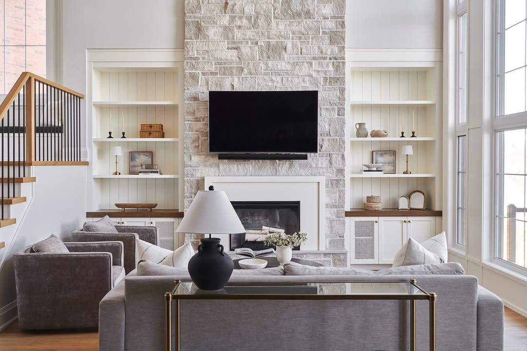 A living room with a couch , chairs , a fireplace and a flat screen tv.