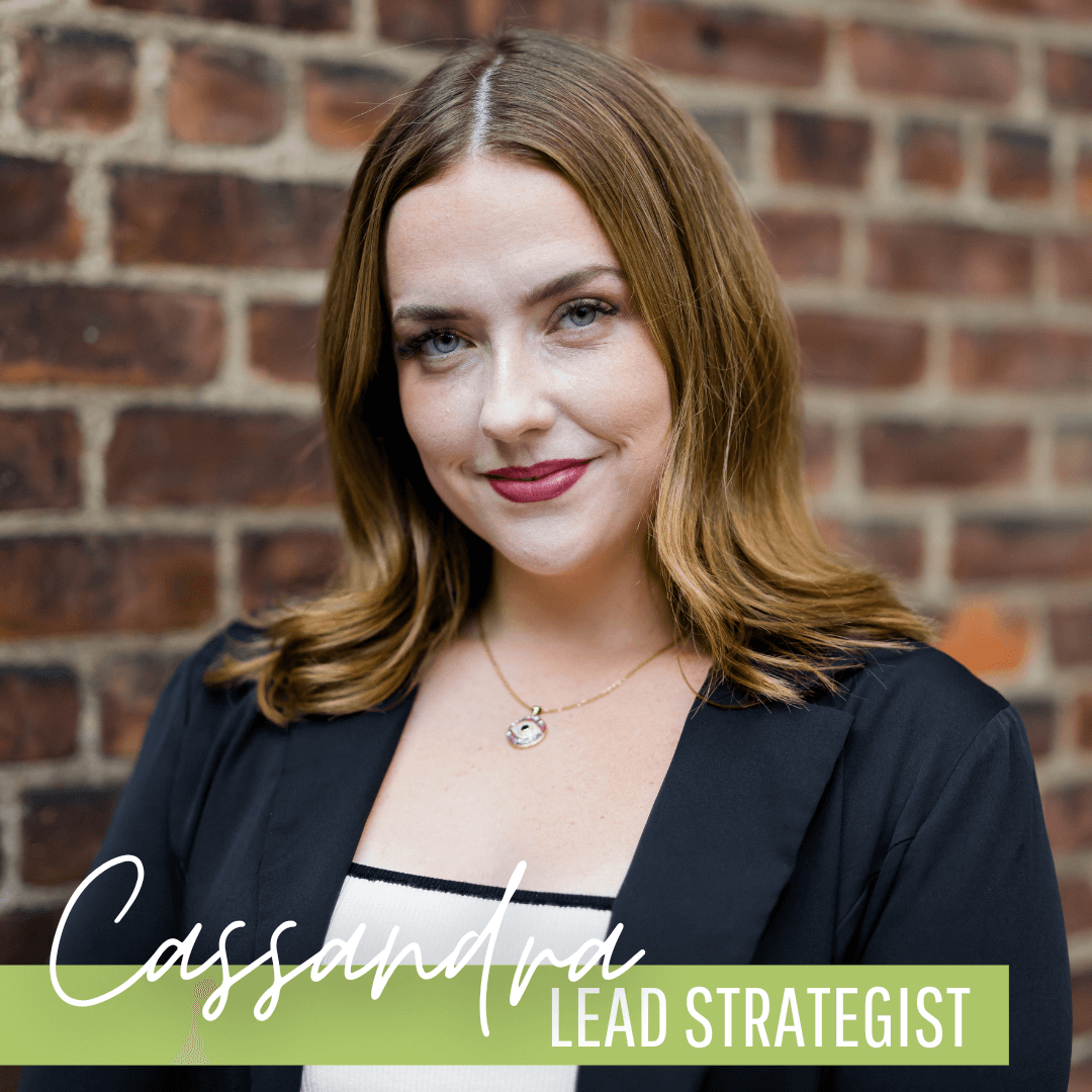 A woman is standing in front of a brick wall and is a lead strategist