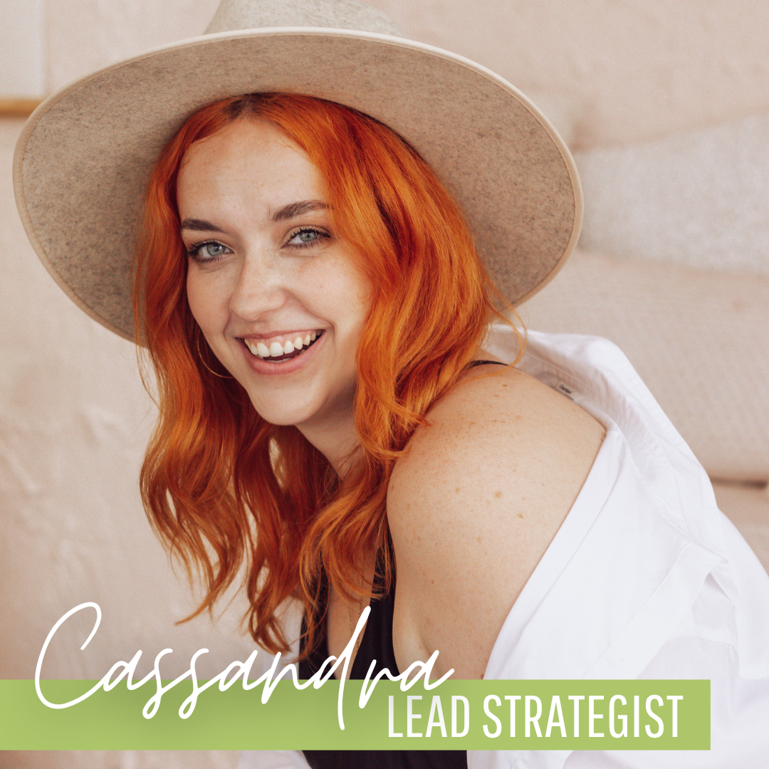 A woman with red hair wearing a hat and the name cassandra lead strategist