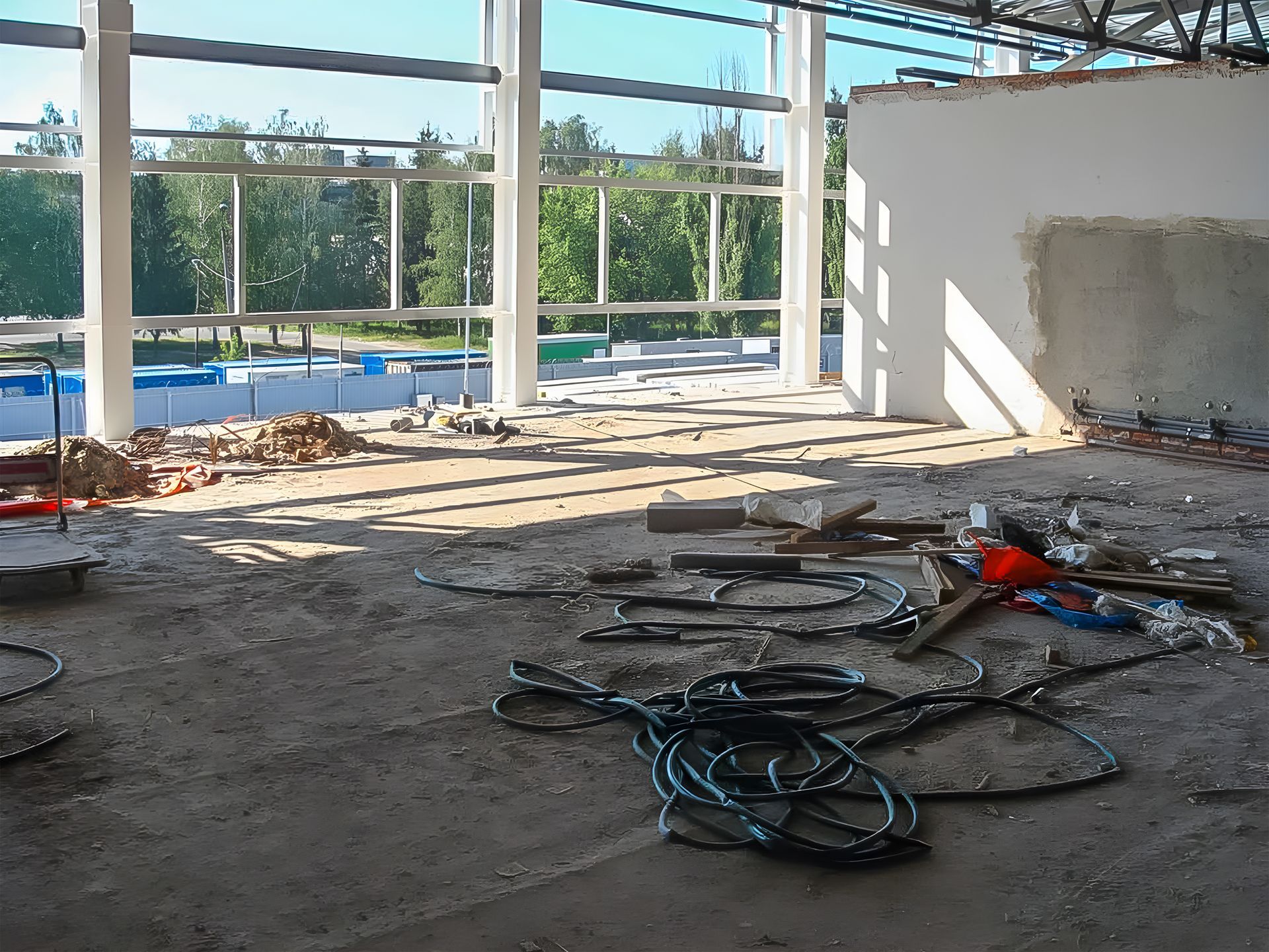 The building interior is under commercial remodel with debris and exposed framing. The building interior is under commercial remodel with debris and exposed framing.