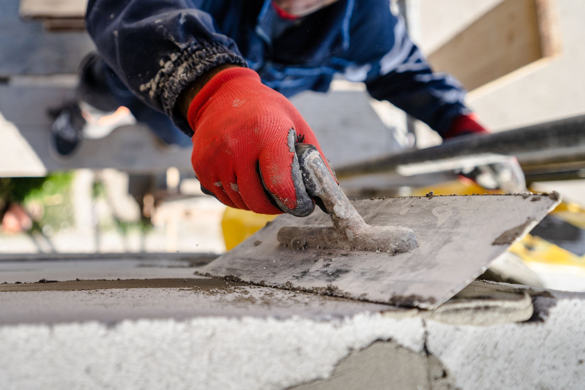 Skilled worker using a trowel for concrete finishing during a commercial remodeling project. Skilled worker using a trowel for concrete finishing during a commercial remodeling project.