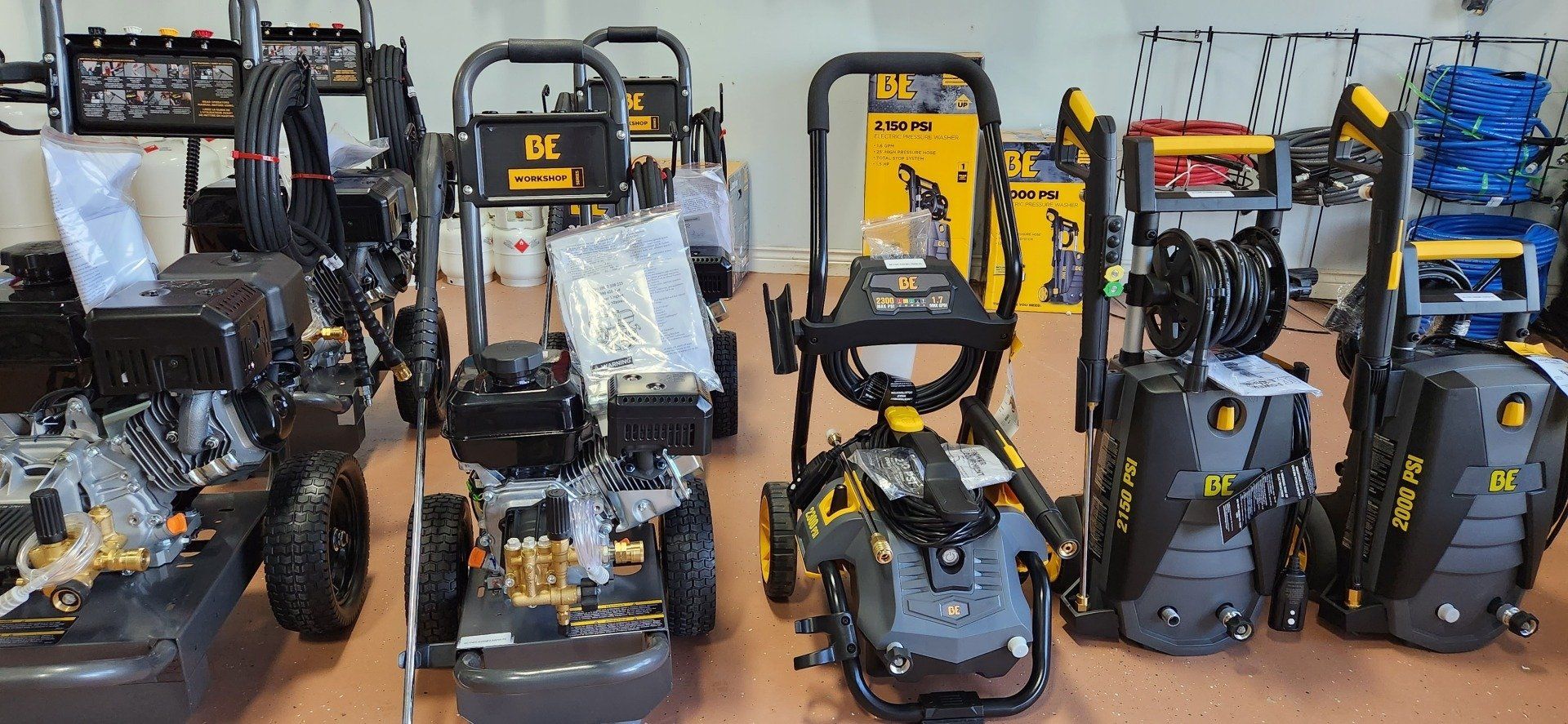 Several pressure washers on display in a store, most are black and yellow.