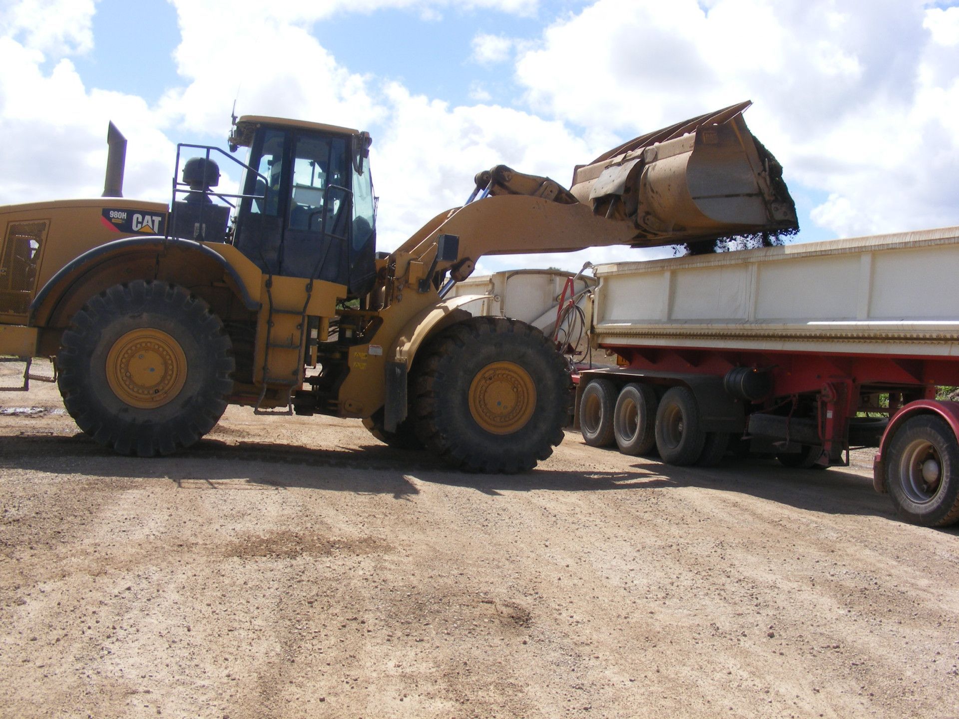 Large Yellow Dump Truck is Being Loaded With Dirt in a Quarry — W Wall & Sons in Nebo, QLD