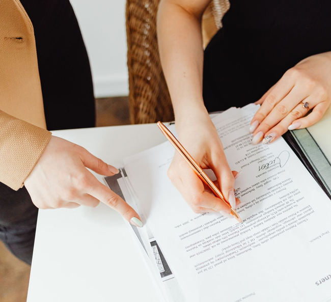 Hands pointing and writing on a documents during a team meeting