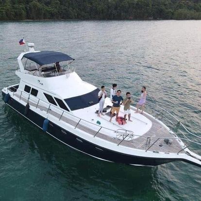 A group of people are standing on the deck of a boat in the water.