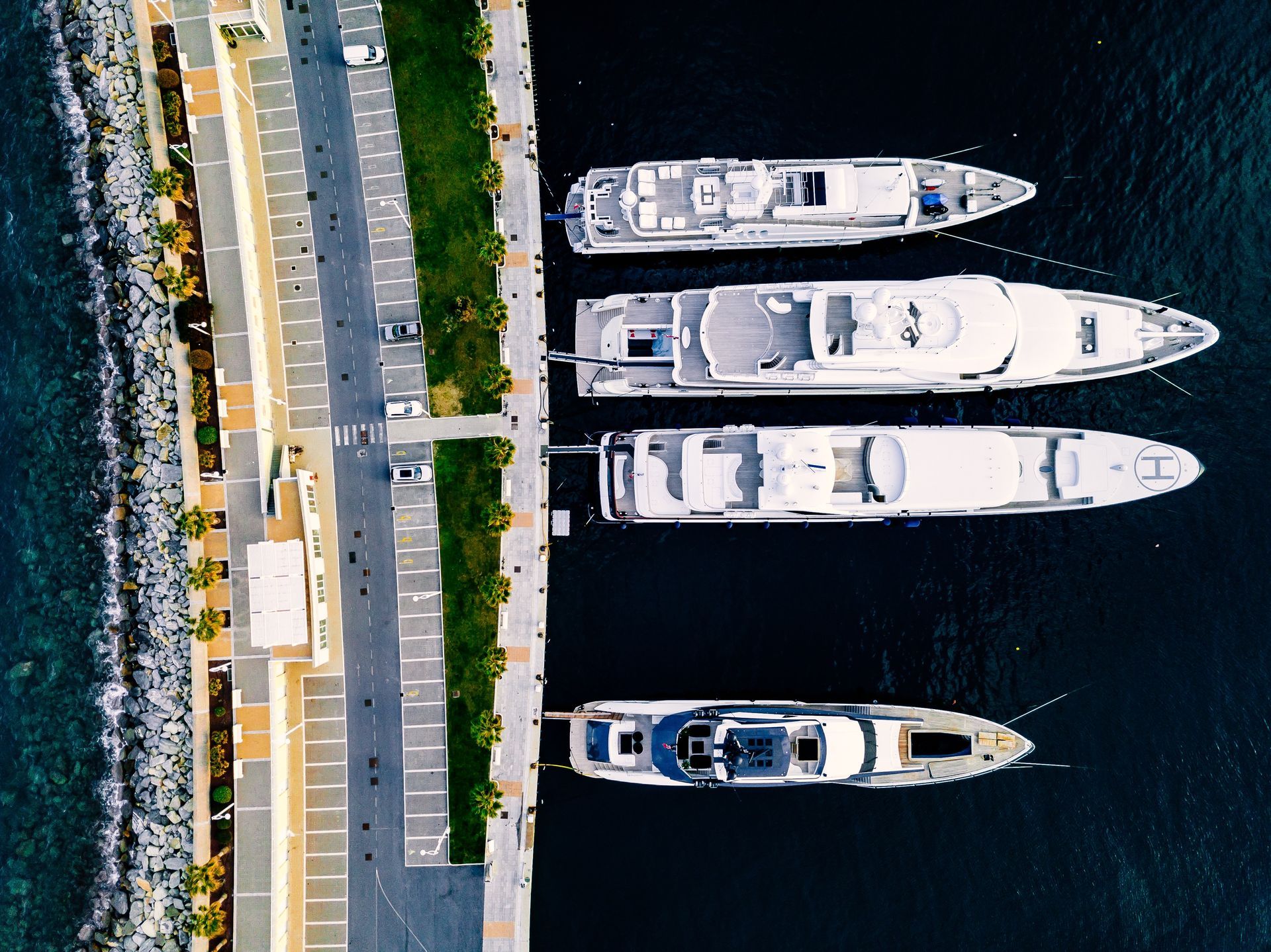 An aerial view of four boats docked in a harbor