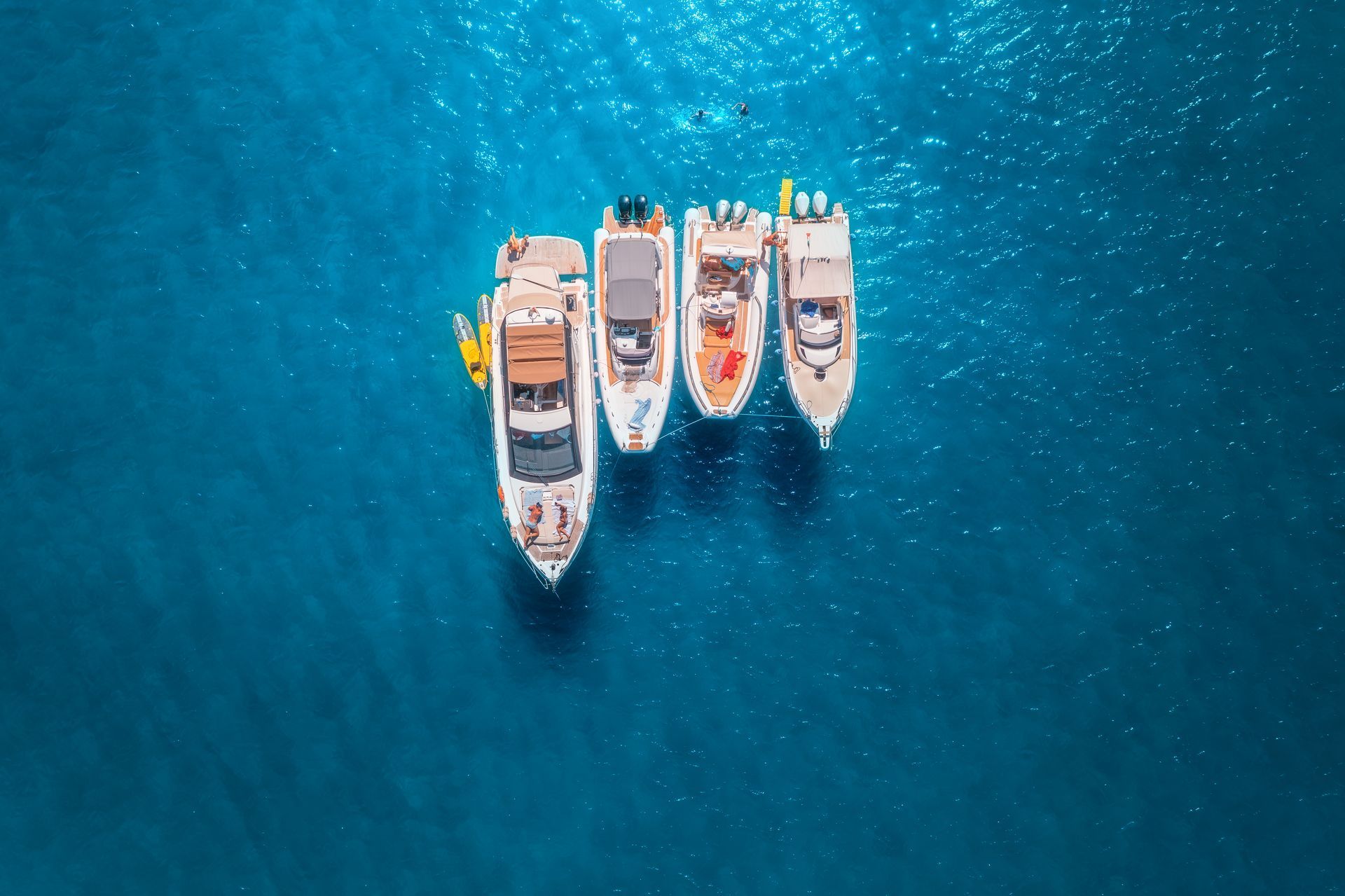 A group of boats are floating on top of a large body of water.