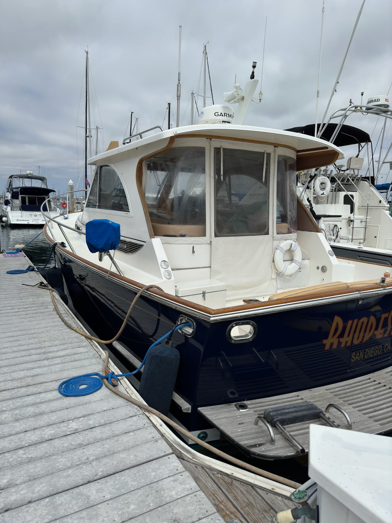 Blue and white motorboat with restored wood trim and clear windows