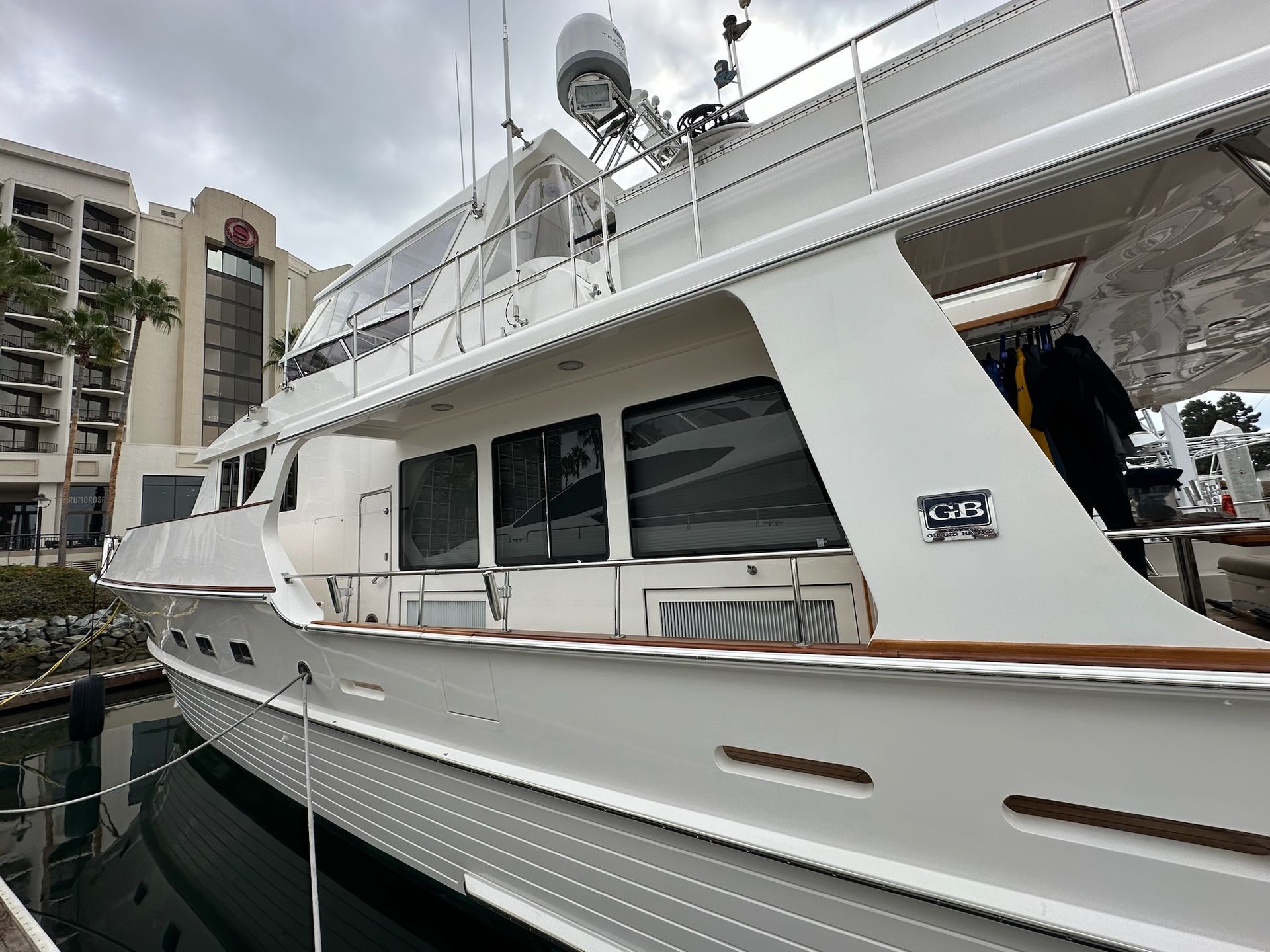 Detailed white yacht docked beside a waterfront building