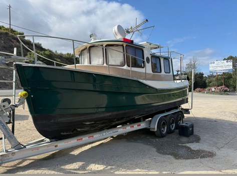 Restored green and tan tugboat exterior on a trailer