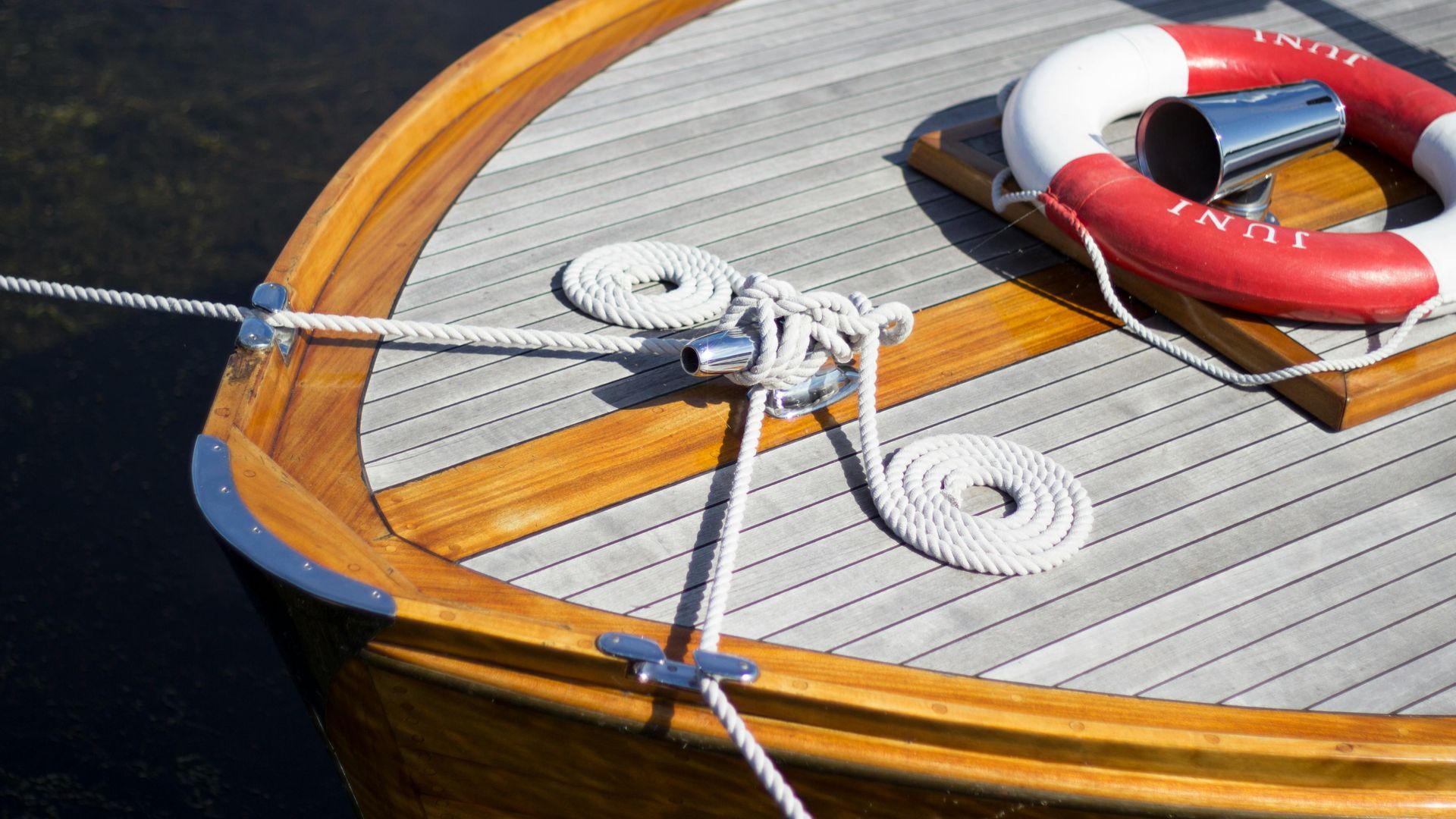A yacht is being roped to the shore for security.