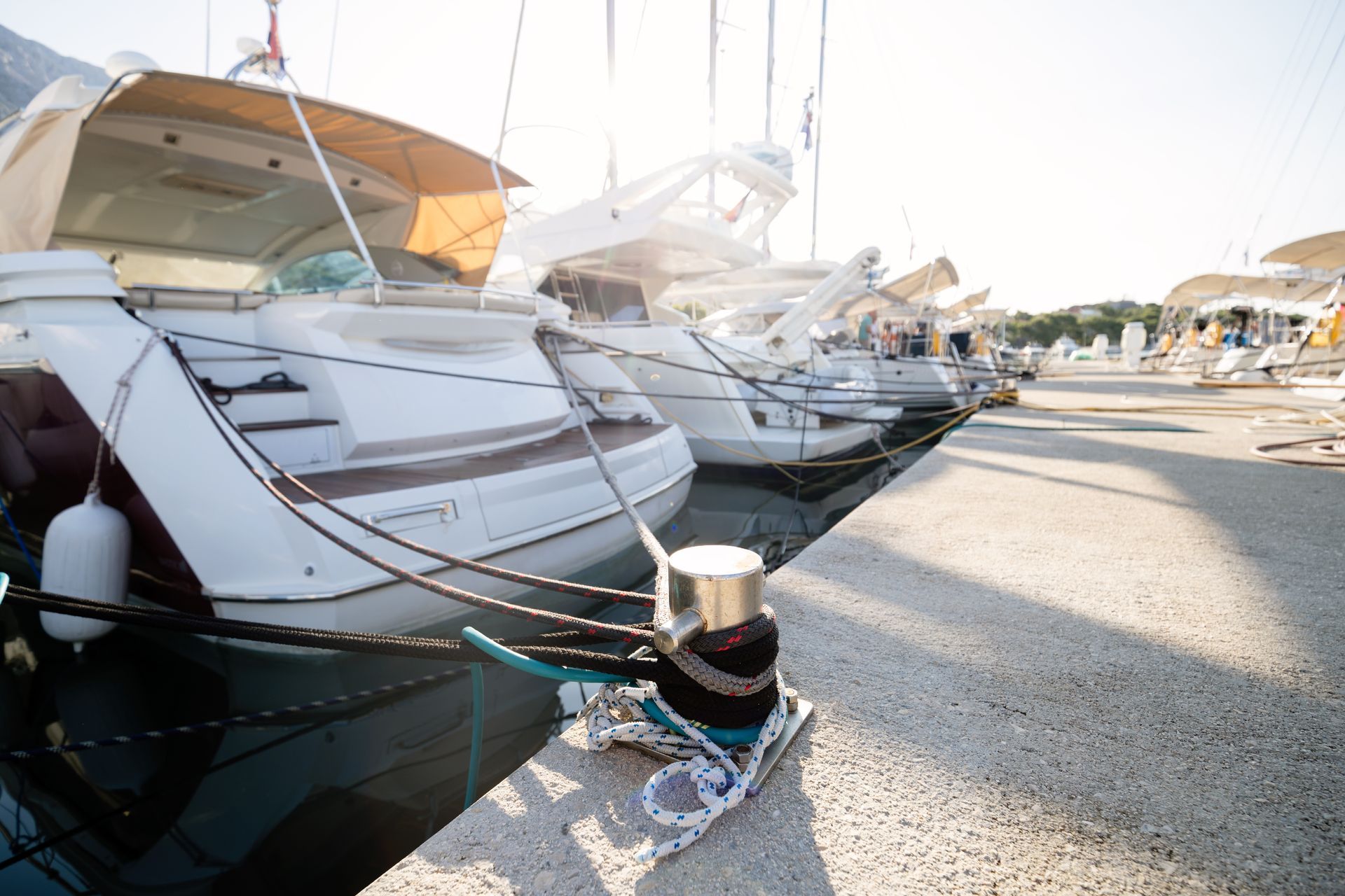 A row of boats are docked in a marina.