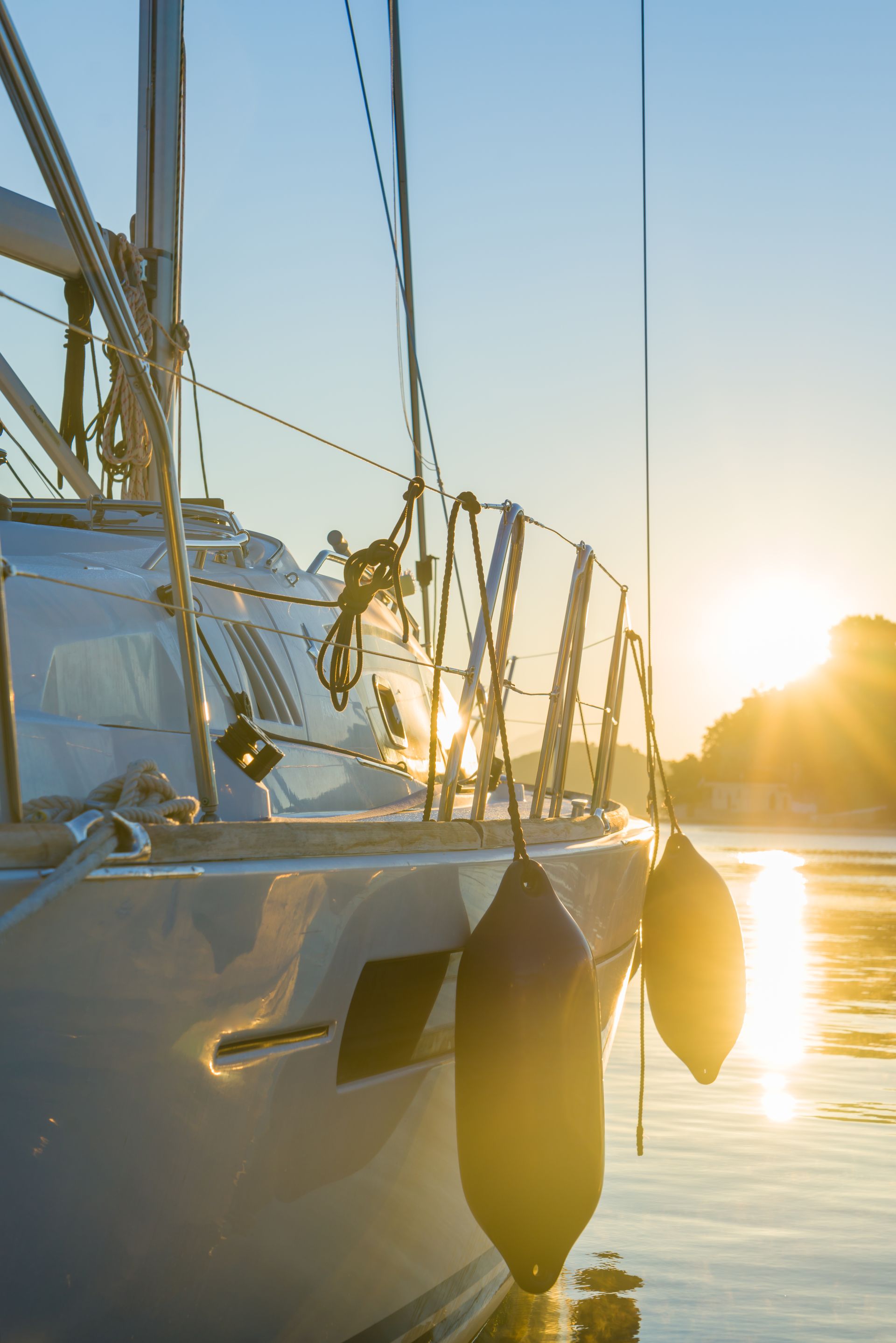 A sailboat is docked in the water at sunset.