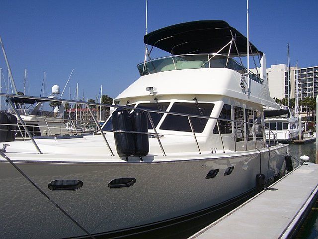 A large white boat is docked at a marina