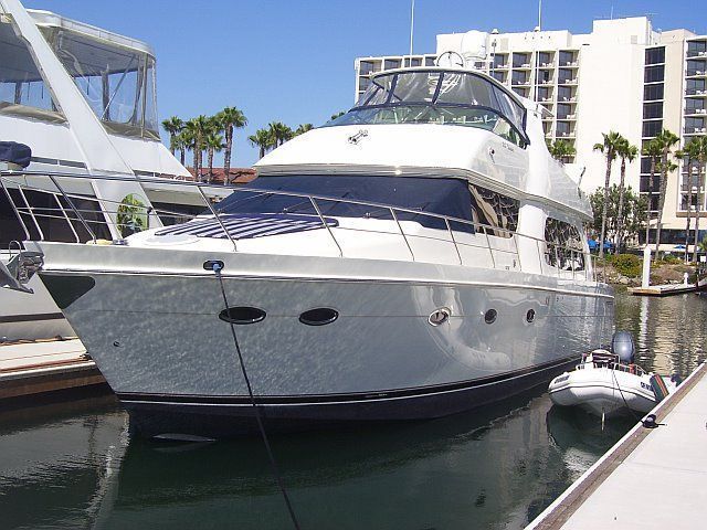 Polished motor yacht near palm trees at a San Diego marina