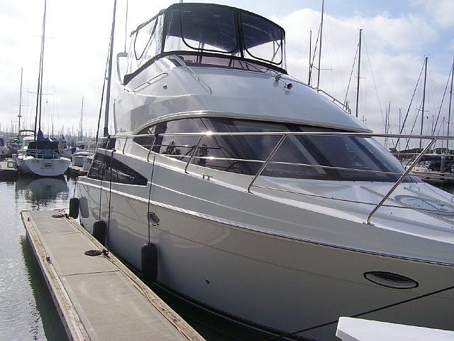 Polished white motor yacht docked on a sunny day