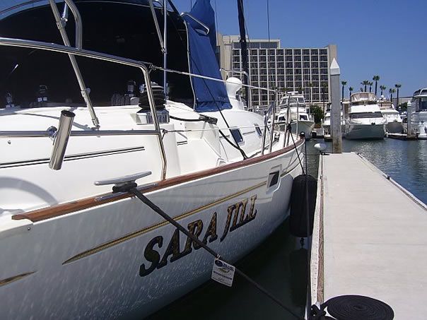 A boat with the name sara on the side is docked at a dock