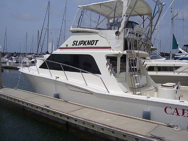 A boat named slipknot is docked at a marina