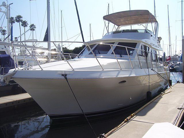 Detailed white yacht with covered upper deck at a marina