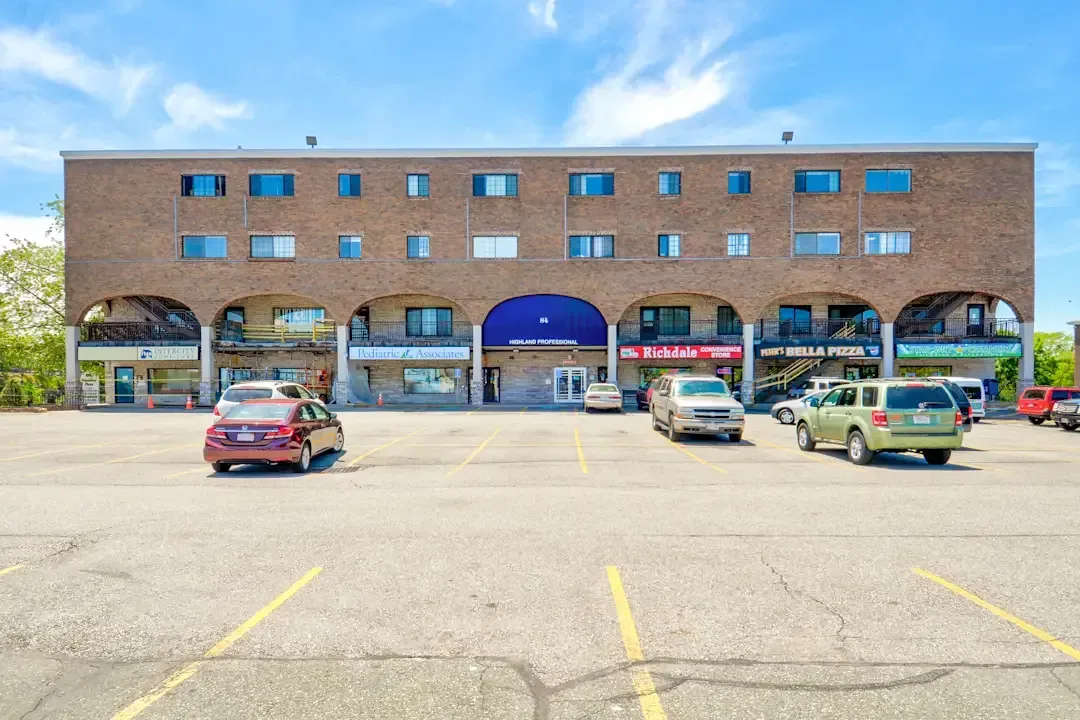 A large brick building with cars parked in front of it.