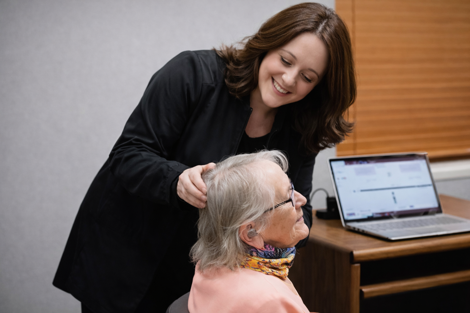 A certified audiologist performing an ear examination with an otoscope in a medical clinic.