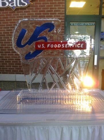 Blue and red U.S. Foodservice ice sculpture displayed on a table indoors at night.