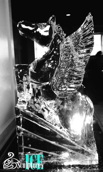 Black glass sculpture of a rearing horse with clear wing-like wings on a reflective pedestal