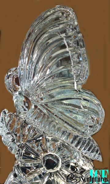Clear glass butterfly figurine with etched wings on a brown background