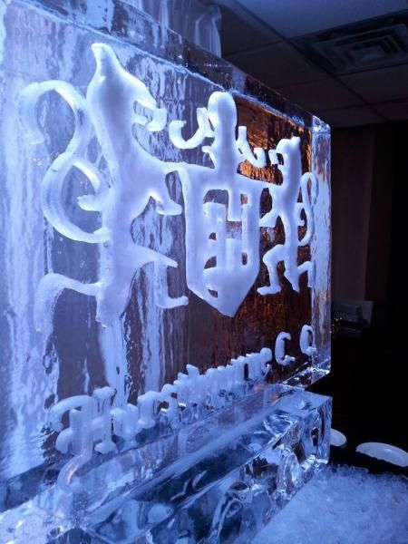 Ice sculpture with stylized Chinese characters, lit blue in a dark indoor setting