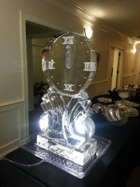 Transparent crystal ice sculpture on a banquet table in a hallway, lit from below.