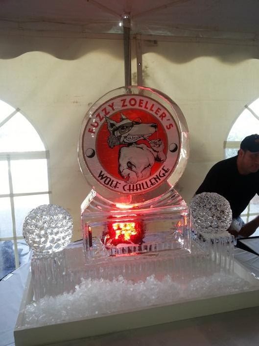 Ice sculpture display with a red-lit central plaque reading “Miley Zoeller,” under a white tent.