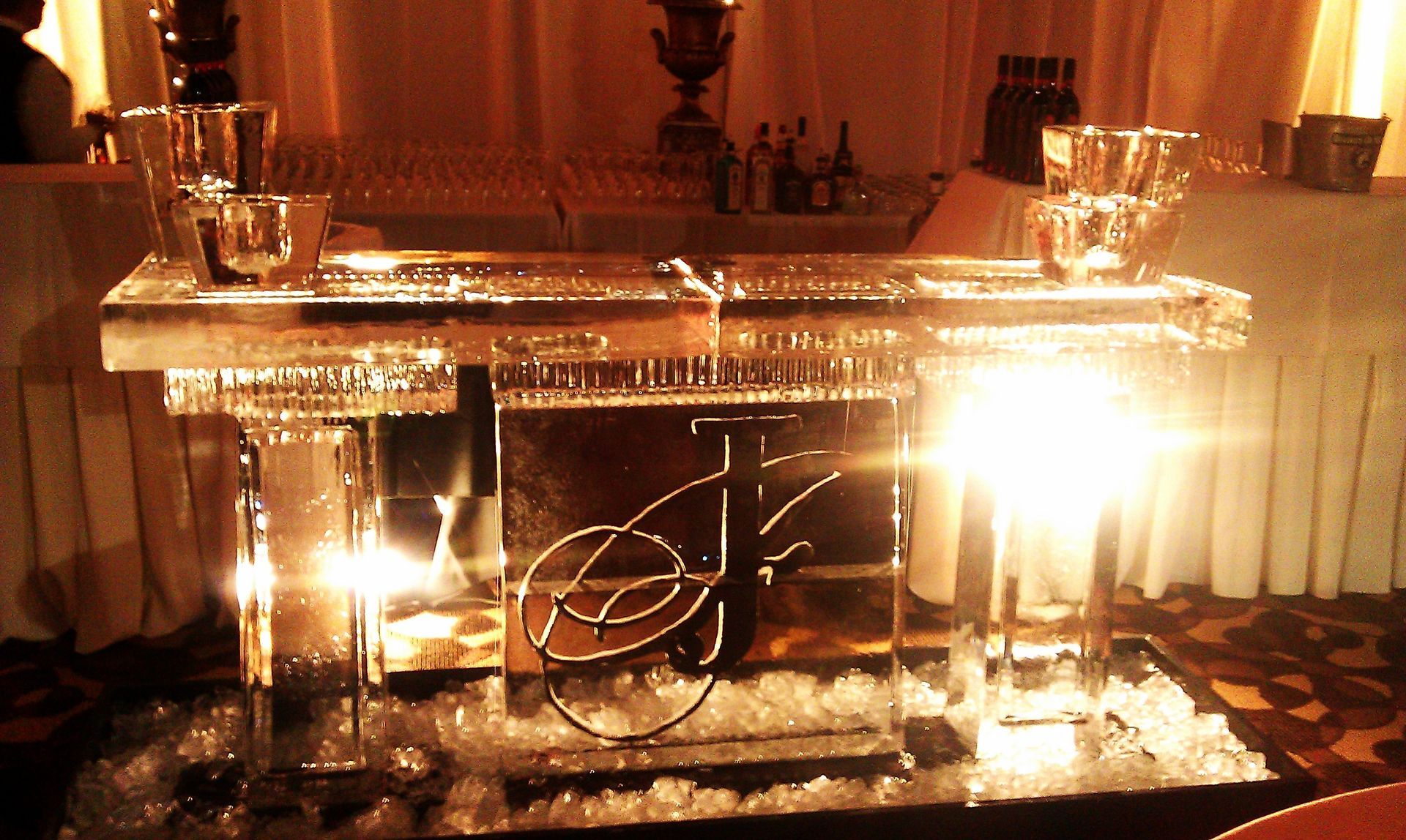 Decorative glass and candle centerpiece on a banquet table, glowing warmly at an event