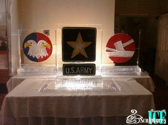 Three military-style plaques with eagle, star, and red emblem, labeled U.S. Army on a table.