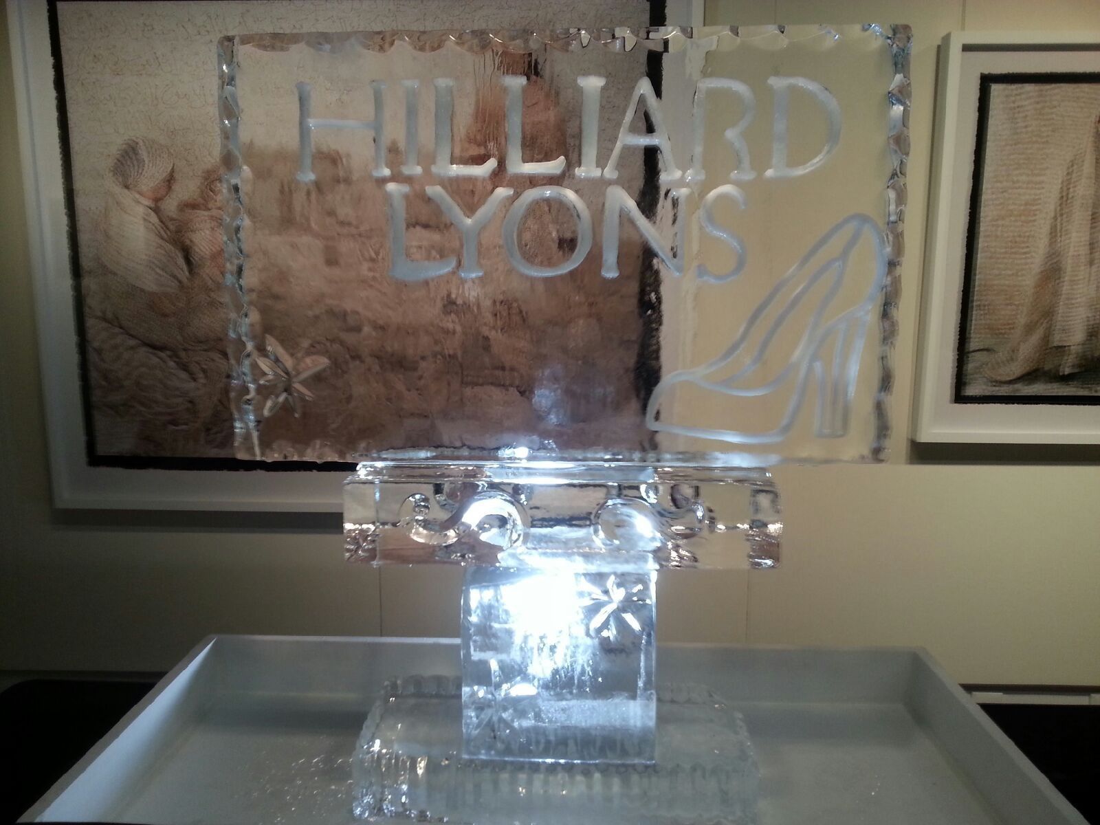 Clear Hilliard Lyons acrylic sign on a silver tray in a lobby display case