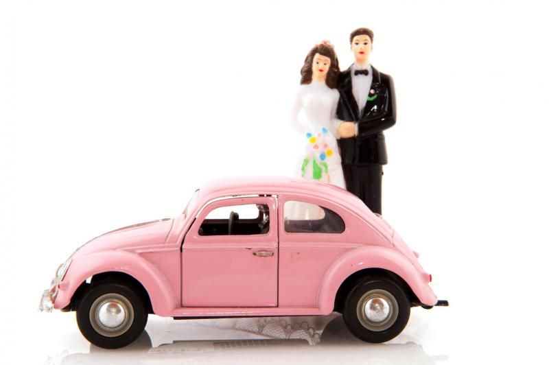 Pink toy car with bride and groom figurines on the roof
