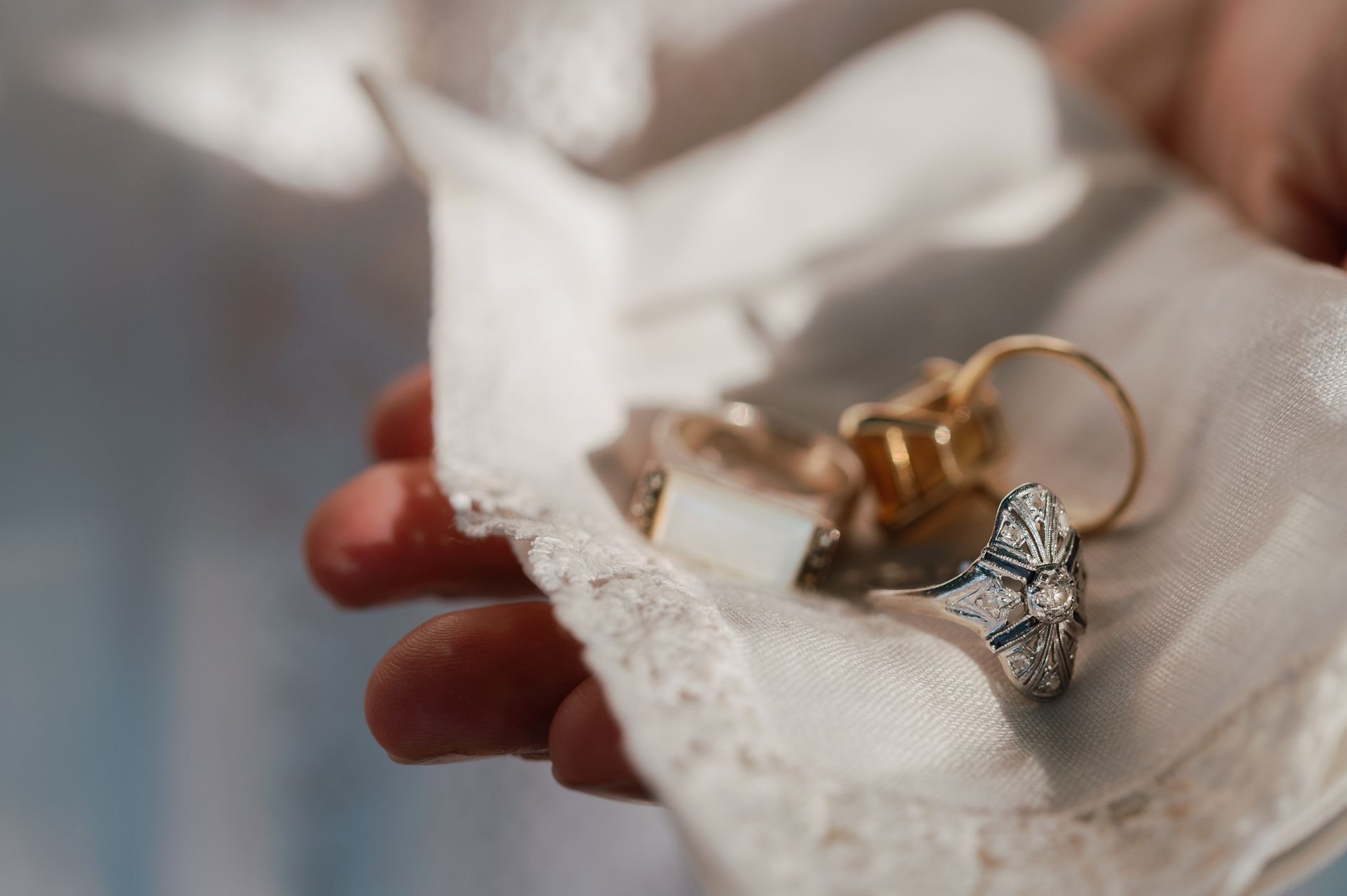 Handful of heirloom rings on a white handkerchief.