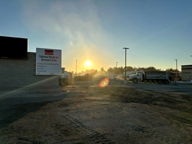 Construction site at sunrise, with a sign for 