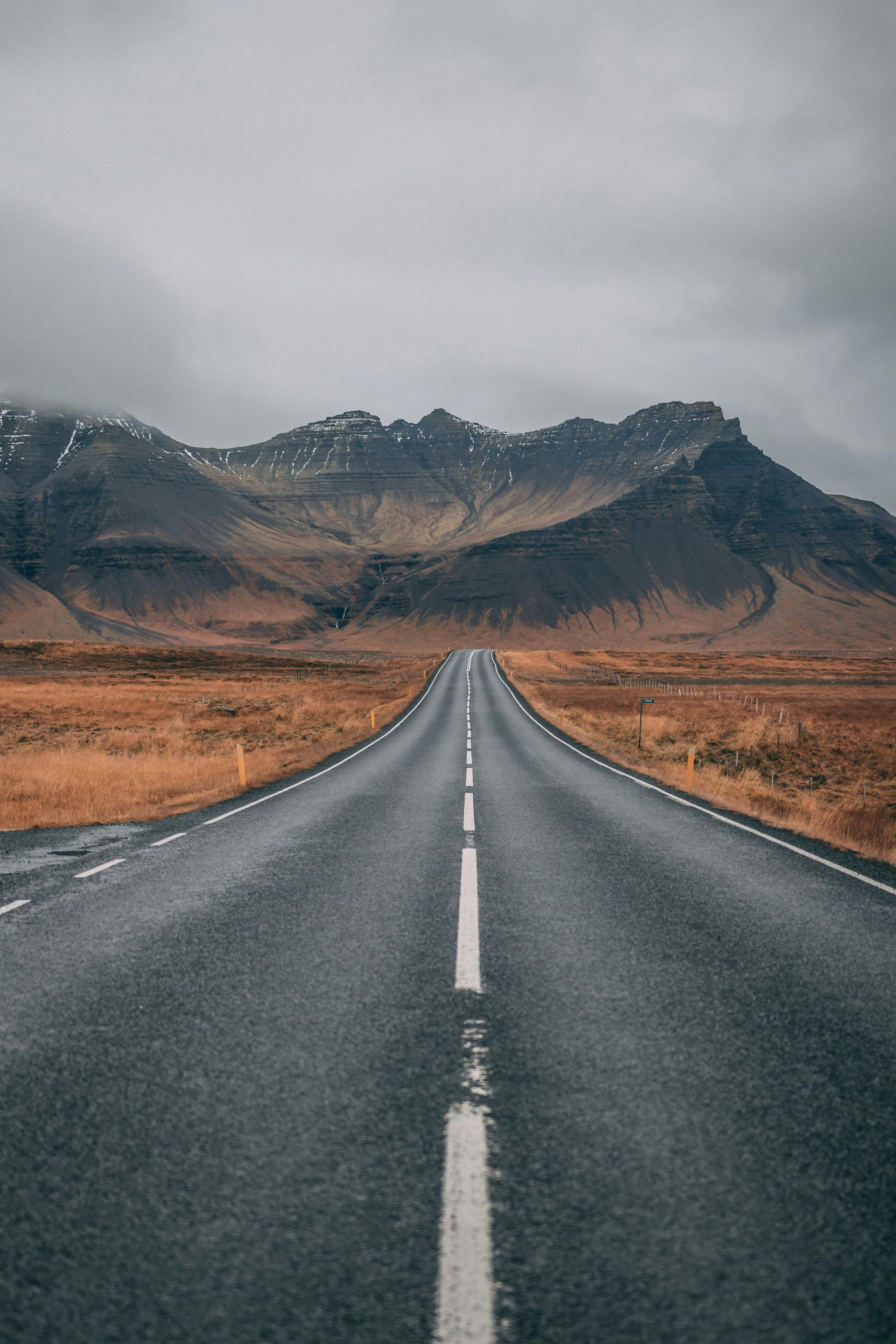 An empty road going through a desert with mountains in the background - Carmen & Co Consulting Strategic Consulting in Southeast Queensland