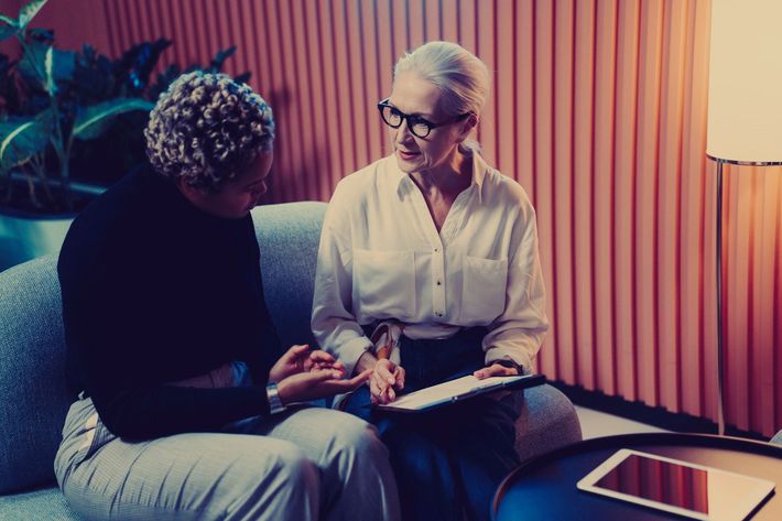 Two women are sitting on a couch looking at a tablet - Carmen & Co Consulting Strategic Consulting in Southeast Queensland