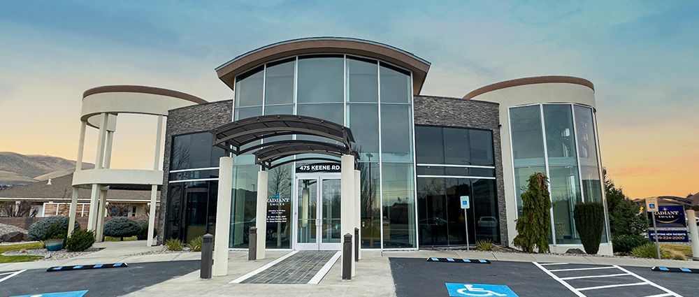 A large glass building with a handicapped parking spot in front of it.