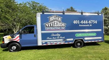 Blue Brian Viveros contracting truck parked on grass with company phone number and logos on the side