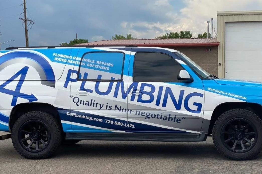 Blue plumbing service pickup truck with company branding parked outdoors