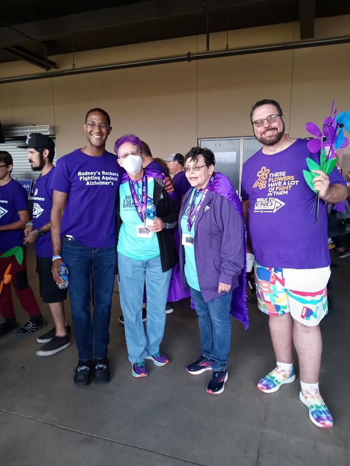 A group of people wearing purple shirts are posing for a picture.