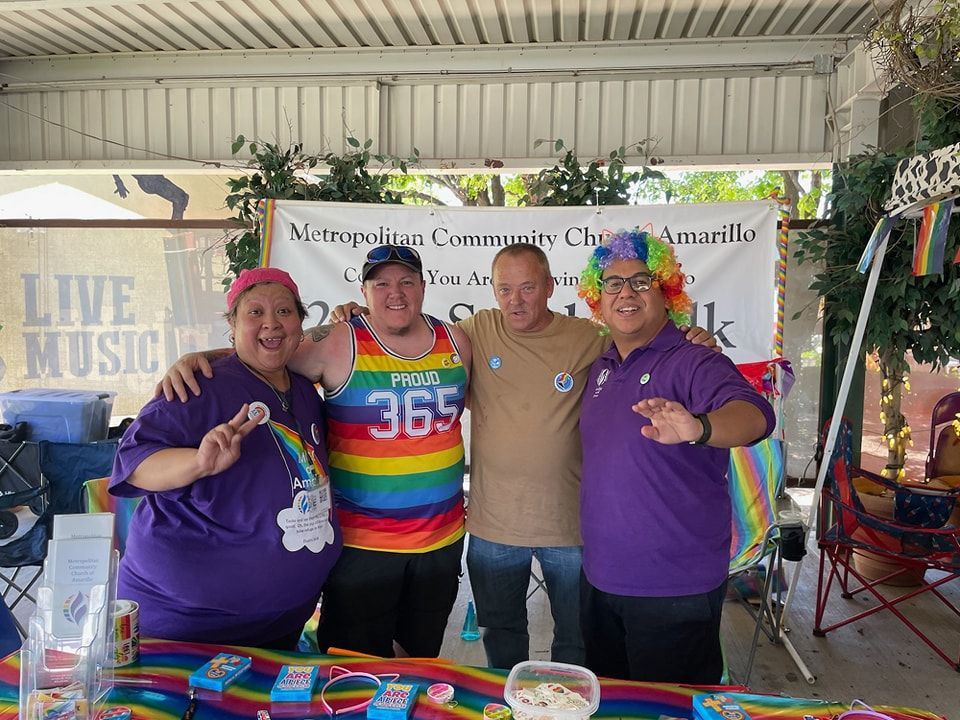 A group of people are posing for a picture in front of a rainbow table.