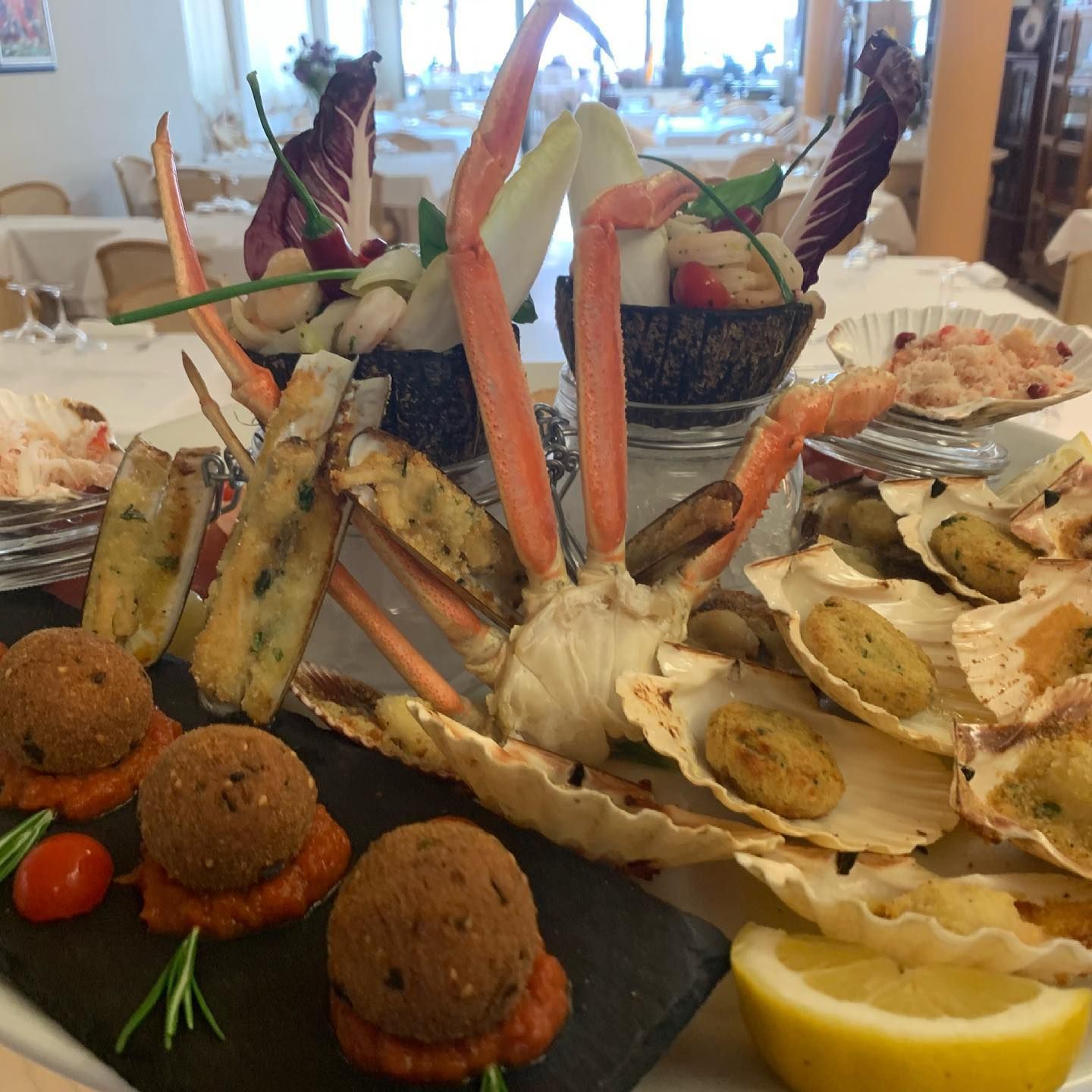 Un piatto di cibo con zampe di granchio e verdure su un tavolo