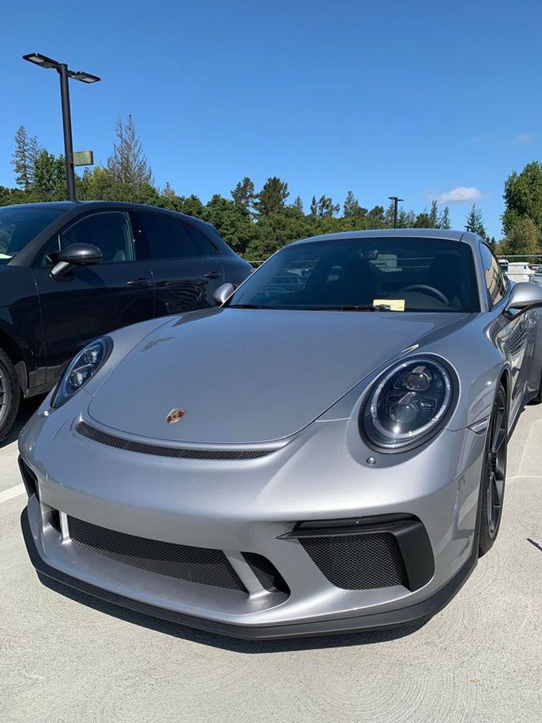 A silver porsche 911 gt3 rs is parked in a parking lot.
