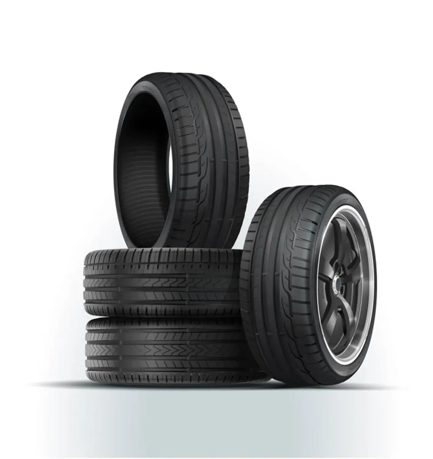 Stacked black car tires on a white background, with one tire standing upright at the front.